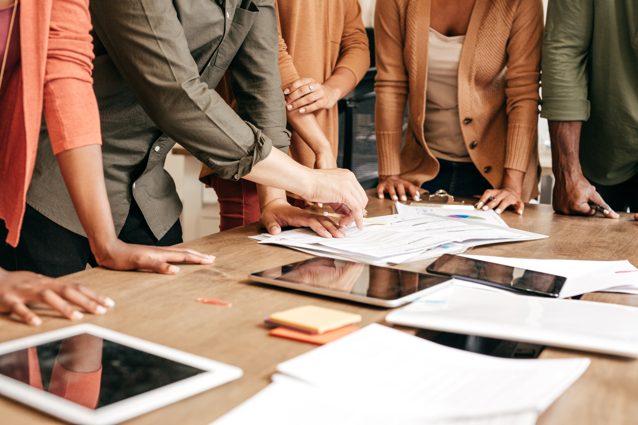 Équipe réunie autour d’une table, échangeant sur une stratégie de communication FOOH, illustrant la collaboration et la réflexion collective pour concevoir des campagnes digitales impactantes et modulables.
